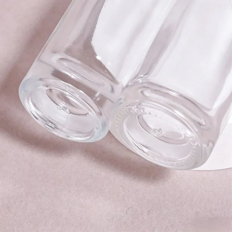 Close-up of the bases of two clear round glass serum bottles
