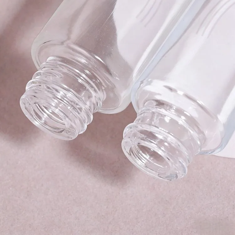 Close-up of two clear round serum bottle openings without droppers