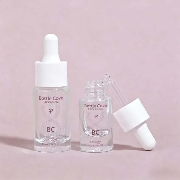 Two clear glass serum bottles with white droppers on a pink background